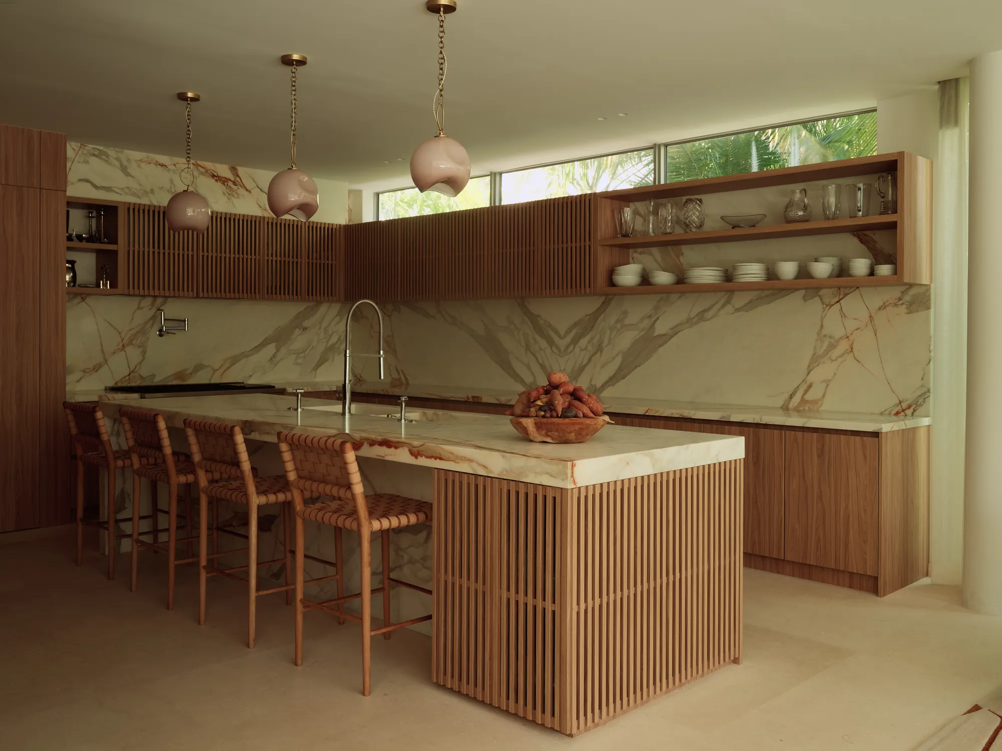 Kitchen with stone countertops and a warm wood island in the Broadview residence by LUXOM