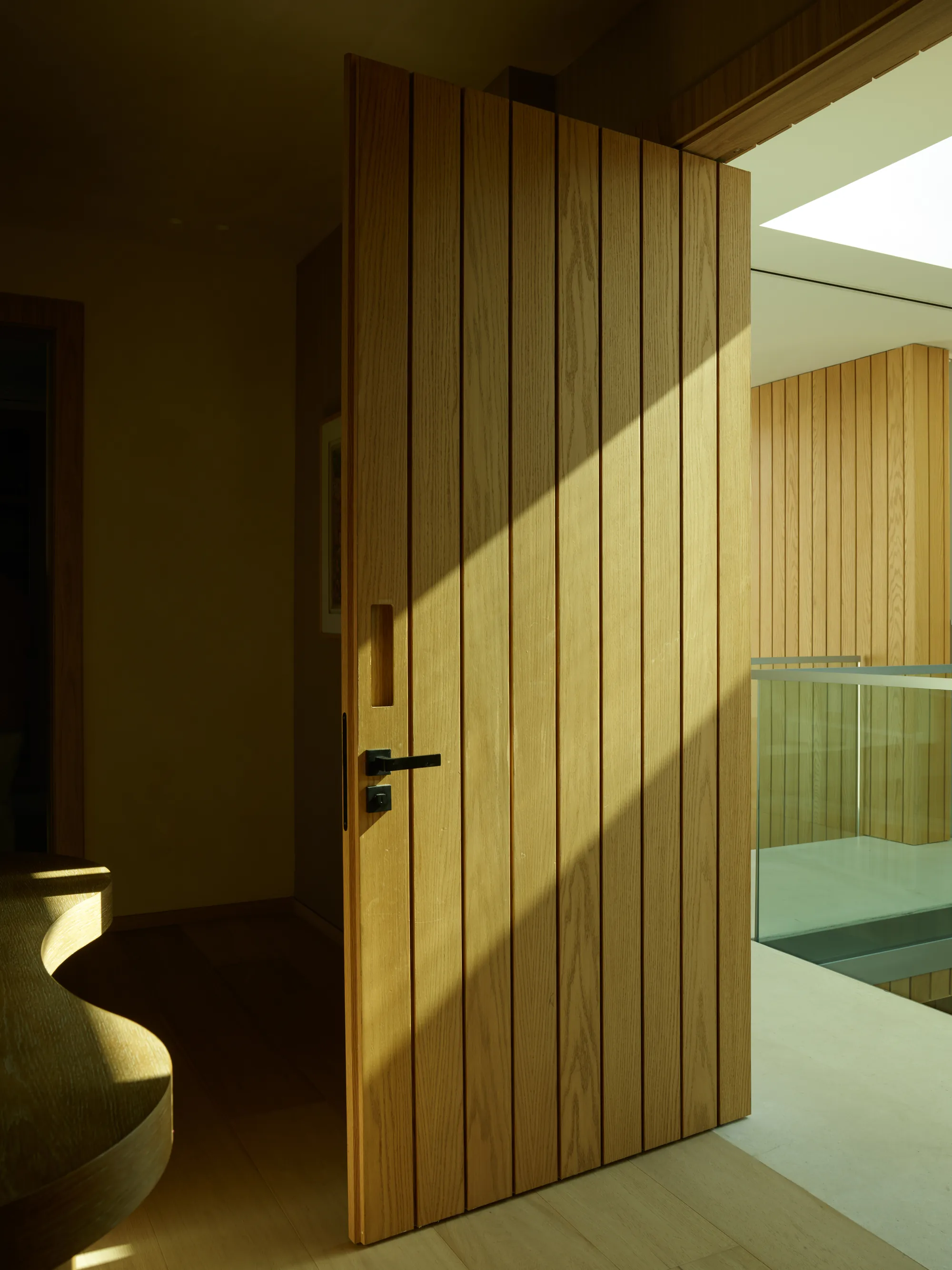 Interior living space at the Broadview Residence in Coconut Grove, Miami, showing the material palette carried consistently around the room's fixed architectural features
