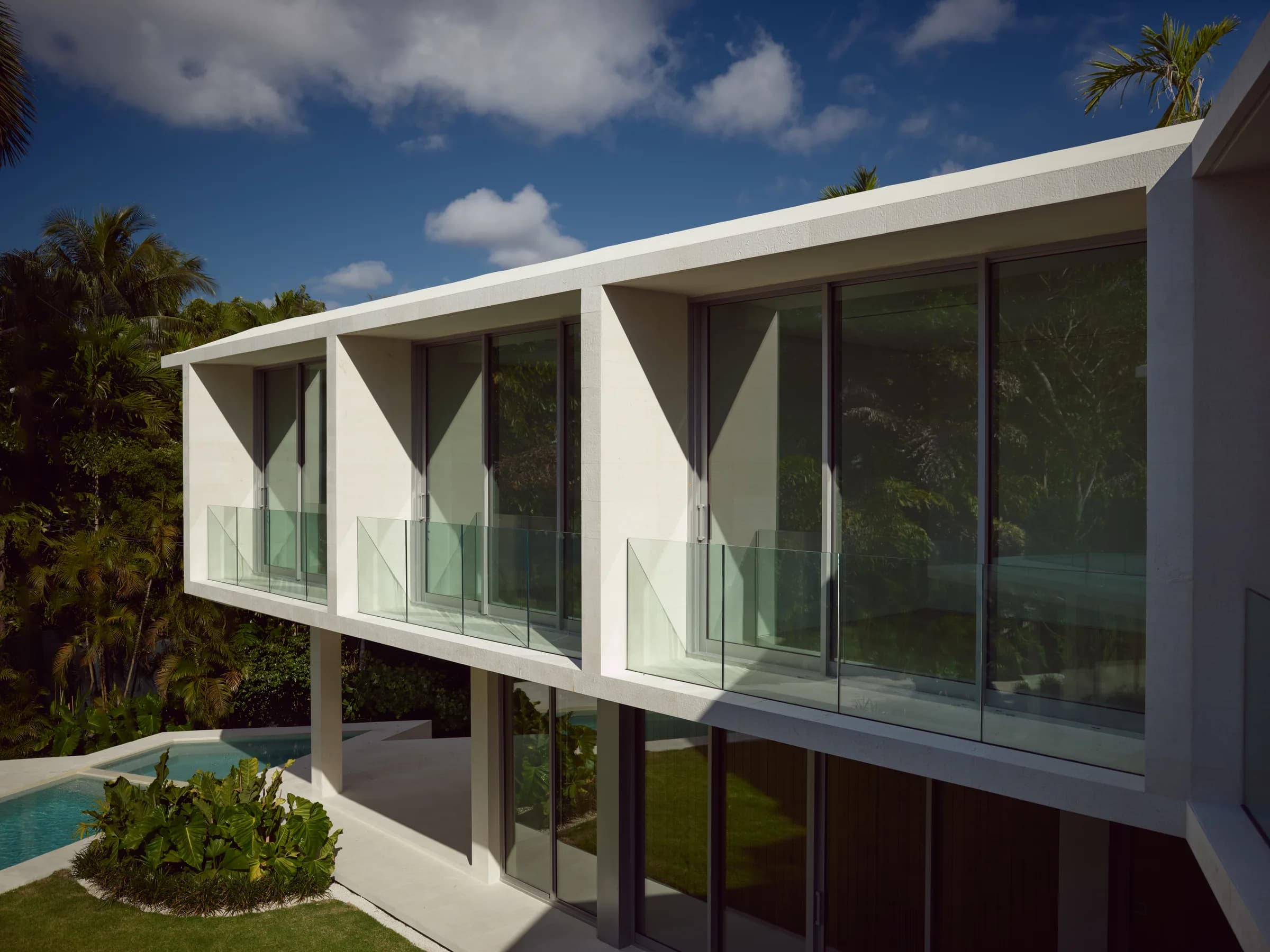 Exterior of the Ingraham residence by LUXOM, a crisp modern volume over water in Miami