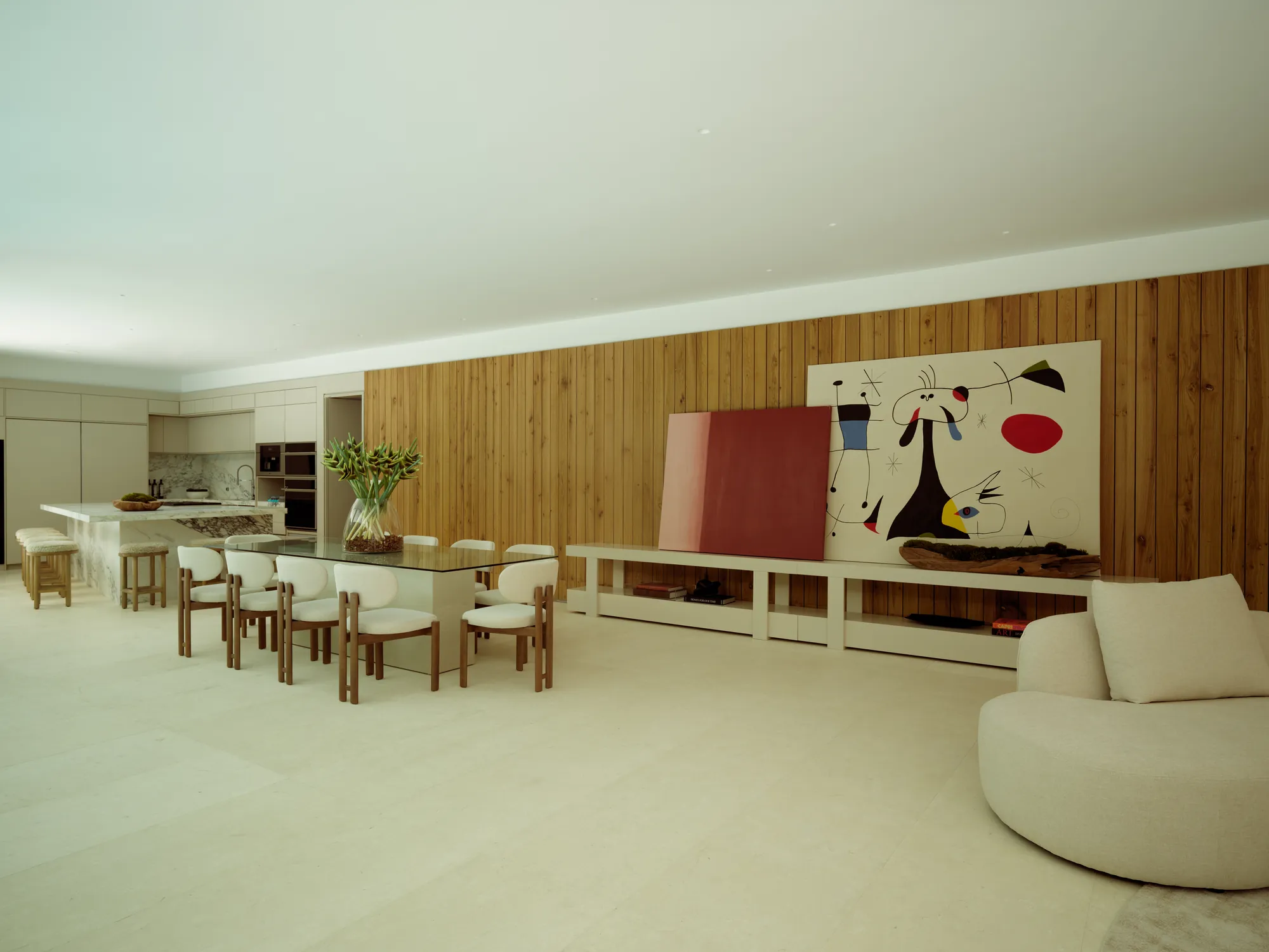 Open dining and living space with a warm wood feature wall in the Onaway residence by LUXOM, Miami