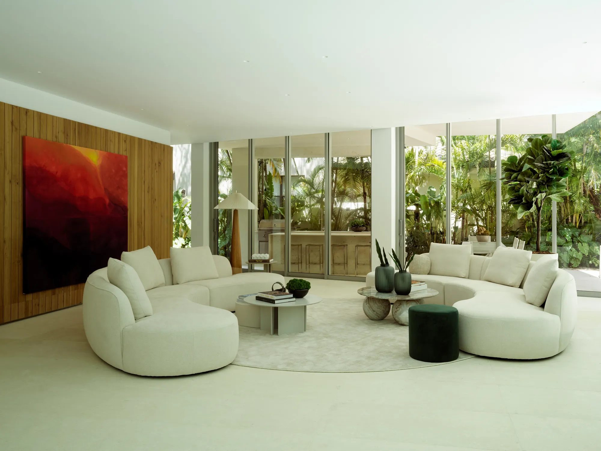 Fully renovated living room with sculptural seating and garden views in the Onaway residence by LUXOM, Miami