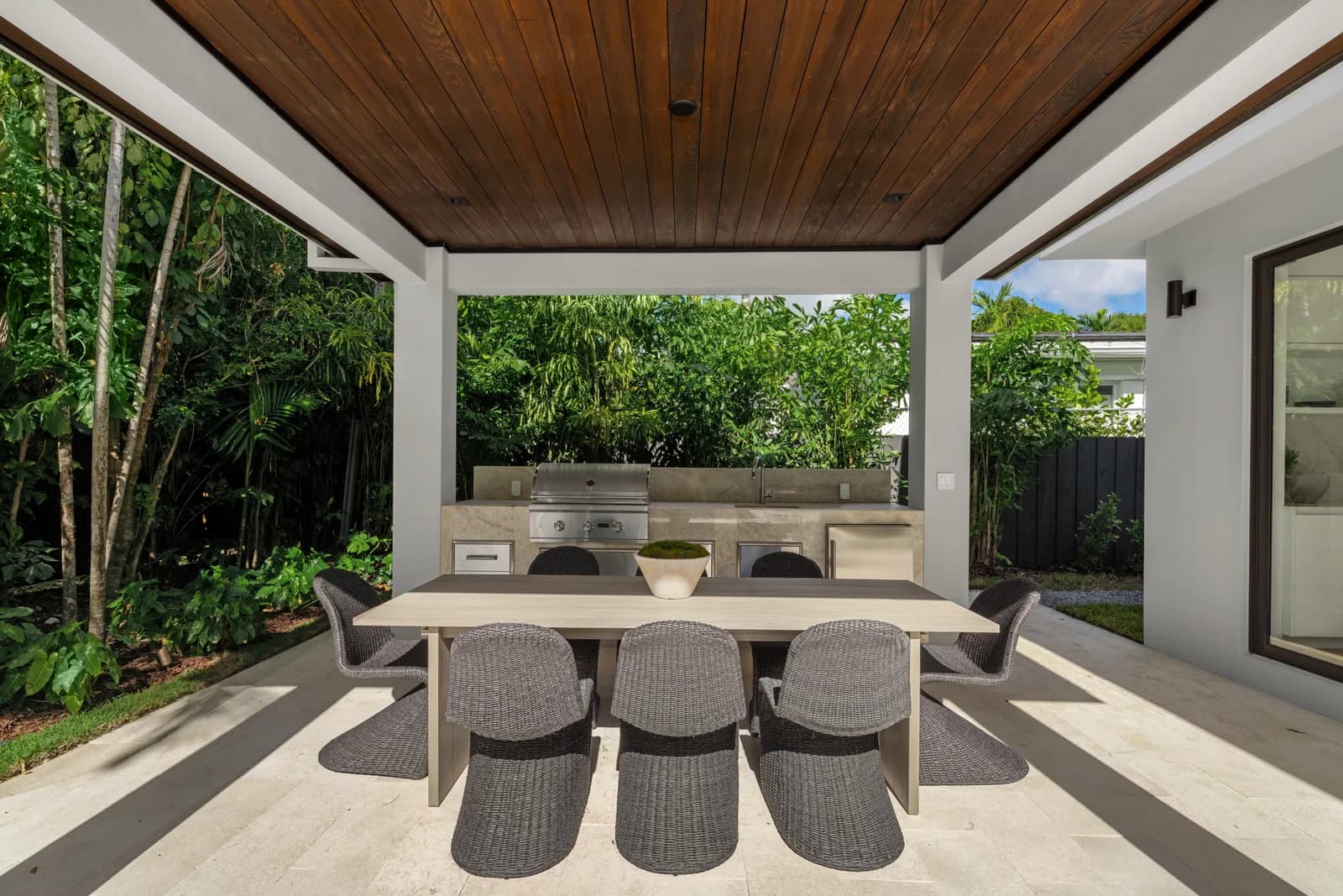 Covered outdoor dining pavilion beside the pool in the Pinta residence by LUXOM, Miami