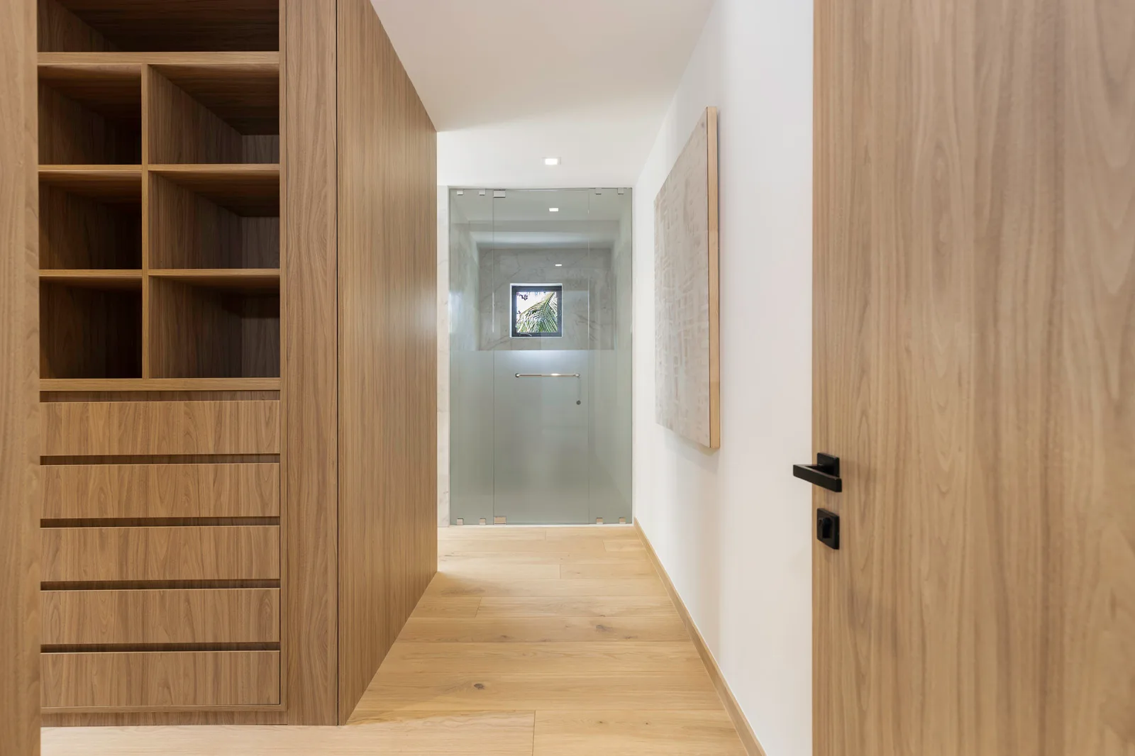 Walnut and white oak joinery lining a closet hallway in the Samana residence by Luxom